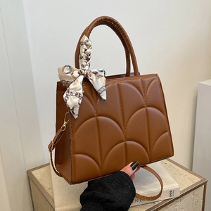 Brown quilted shoulder bag with silk scarf detail and crossbody strap for women