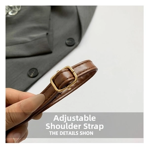 Close-up of adjustable brown leather shoulder strap with gold metal buckle and stitching