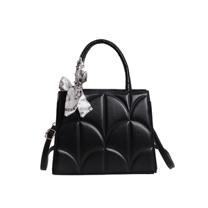 Black retro tote bag with arch quilting and decorative silk scarf on round handle