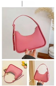 Detail view of pink underarm bag with zipper closure and adjustable shoulder strap