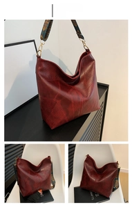 Detail view of large red tote bag with a retro textured finish and ethnic pattern strap