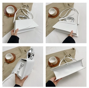Detail view of white geometric square bag with unique silver metallic handle and PU leather