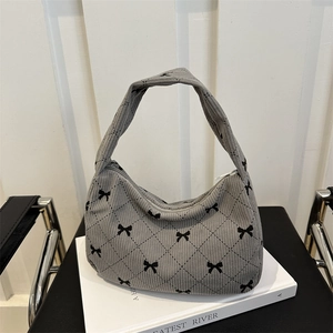 Gray corduroy hobo bag with black bow pattern and crescent shape for autumn style