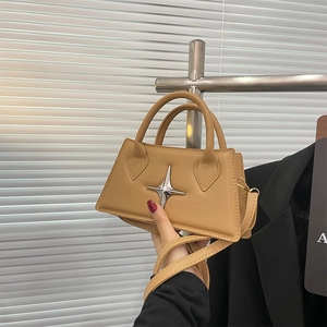 Detail of khaki leather trapezoid handbag featuring a silver star buckle and round handle