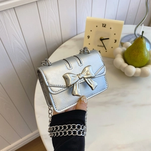 Mini sac bandoulière argenté métallisé avec grand nœud et bandoulière chaîne
