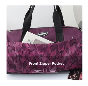 Detail of front zipper pocket on purple camouflage duffel bag showing storage capacity