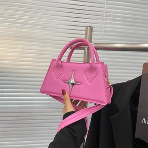 Detail of vibrant pink leather square handbag featuring 3D silver star hardware and strap