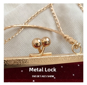Detail showing the elegant golden hardware clasp and velvet fabric with decorative pearls