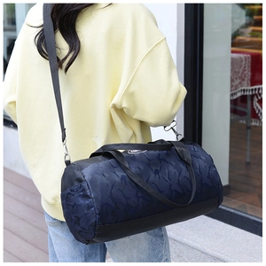 Detail of blue camo nylon travel bag with adjustable strap shown on a model
