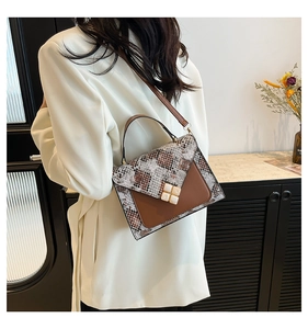 Detail of snake print leather contrast stitching on structured crossbody bag with gold lock