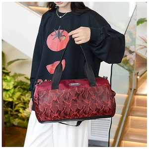 Close-up of burgundy camouflage travel bag with fashion patch and durable nylon strap
