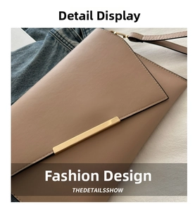 Detail of beige envelope crossbody bag with gold metal bar and fine stitching texture