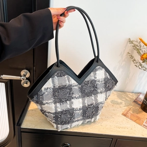 Borsa tote a scacchi bianca e nera con dettagli a frange e manici lunghi in pelle