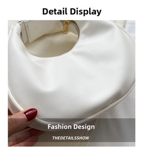 Close-up of white crescent shoulder bag showing premium pebbled leather texture and zipper