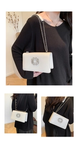 Détail de la grande boucle carrée en strass et chaîne argentée sur le sac en cuir crème