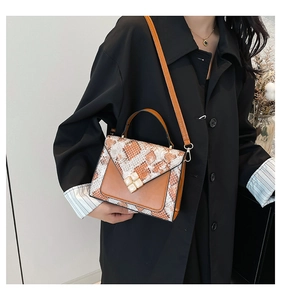 Detail of snake print patch shoulder bag featuring four square white decorative buckles