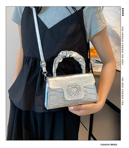 Détail du sac argenté motif crocodile avec boucle en strass et bandoulière réglable