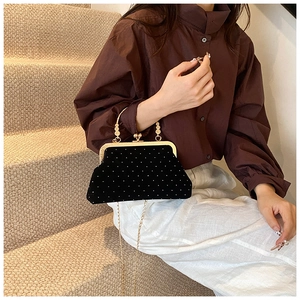 Détail de pochette de soirée en velours noir avec perles et chaîne dorée