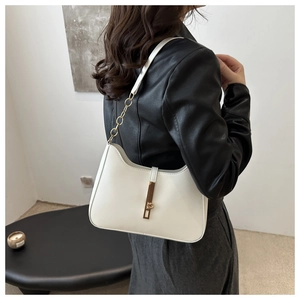 Detail view of white crescent shoulder bag with gold metal buckle and chain strap