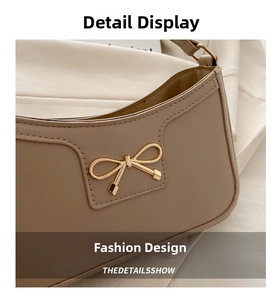 Detailed close-up of cream white leather handbag with elegant gold bow metal buckle