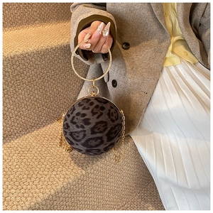 Detail of leopard print ball clutch bag with crystal-encrusted gold metal handle and chain