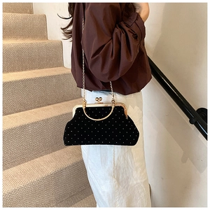 Detail of vintage black velvet kiss-lock shell bag with gold handle and chain strap