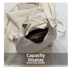 Interior view of white half-moon bag showing storage capacity for wallet and daily items