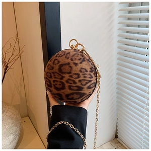 Close-up of stylish leopard print spherical bag with golden ring handle and chain strap