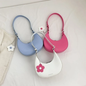 Three minimalist crescent hobo bags in blue, pink, and white with floral charms
