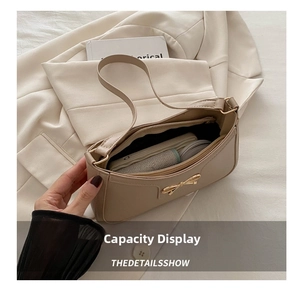Top view of cream white shoulder bag showing interior capacity with golden bow detail