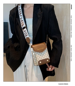 Detail of contrast stitching, brown leather trim and vintage canvas on a flap crossbody bag
