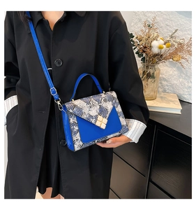 Detail of color-block tote bag with snake skin texture and gold clover-shaped lock