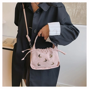 Dettaglio borsa nuvola rosa con applicazioni a farfalla dorata e chiusura a coulisse