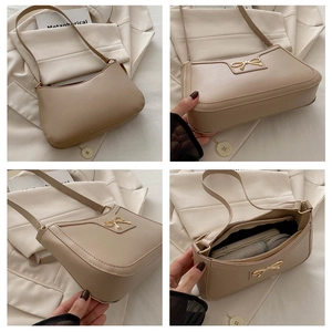 Detail view of beige faux leather shoulder bag with golden bow and spacious interior