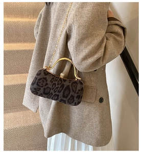 Detailed view of leopard print clutch with gold metal handle and luxury diamond clasp