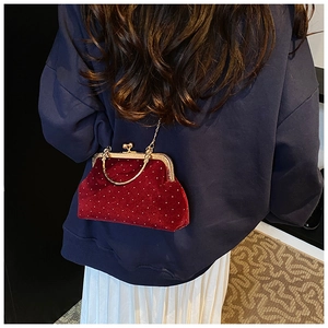 Détail du sac à main en velours bordeaux avec strass scintillants et poignée dorée