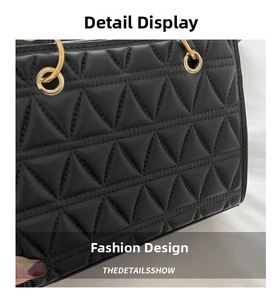 Detail of black quilted handbag with luxury triangular stitching and gold ring handle