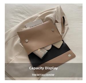 Detail view of large capacity envelope clutch showing interior space for books and wallet