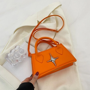 Minimalist bright orange square handbag with silver star detail on a white background