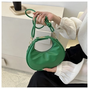 Detail of green hobo bag featuring smooth leather finish and golden metal turn-lock closure