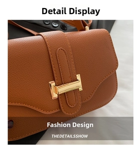 Detail of brown litchi leather bag showing golden hardware buckle and neat stitching