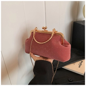 Détail de la pochette en velours vieux rose à pois dorés et poignée métallique