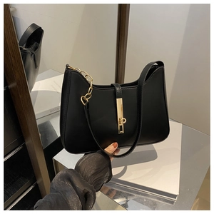 Detail of black PU leather shoulder bag with gold metal chain and decorative buckle