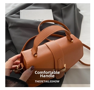 Detailed view of brown lychee grain leather handbag with gold metal clasp and stitching
