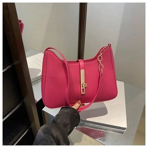 Detail of rose red underarm bag with gold chain strap and vertical metal fastener