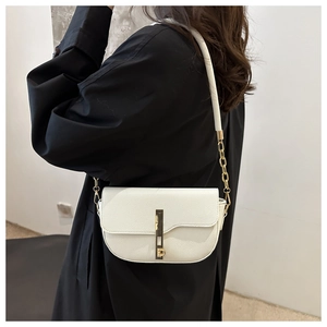 Detail of white lychee pattern saddle bag with gold metal buckle and chain strap