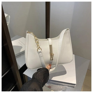 Detailed shot of white faux leather underarm bag with gold metal hardware and chain strap