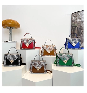 Close-up of snake skin patchwork handbags with pearl clasps in various vibrant colors