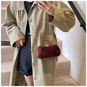 Details der burgunderroten Abendtasche mit Leopardenmuster, Goldgriff und Kettenriemen