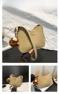 Detail view of khaki PU leather shoulder bag with plush bear charm and fashion text